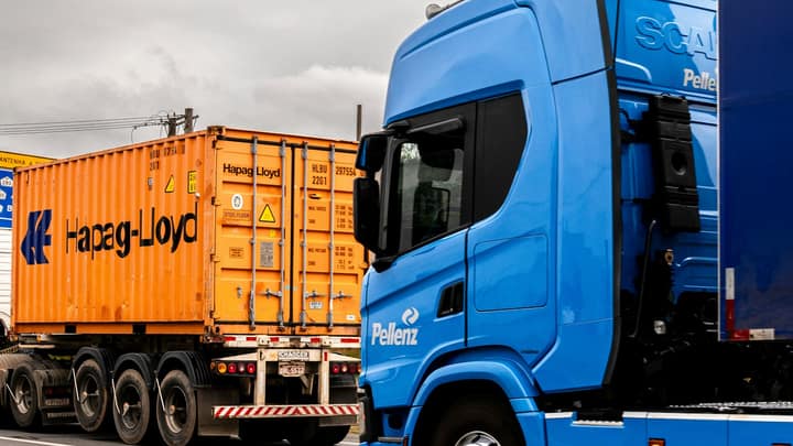A tractor unit hauling a container on a chassis along an open highway